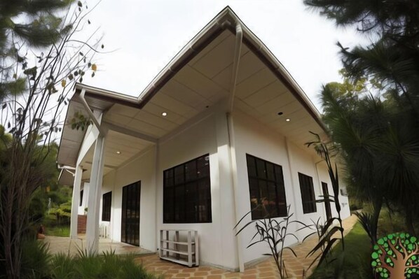Stylish, single-story building with a flat roof and large windows, surrounded by a well-maintained garden.