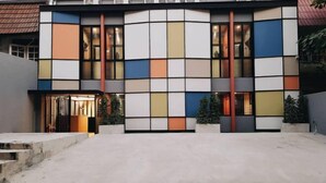 A modern building with a unique facade featuring large, colorful panels. - Kaelyn Cozy Living (Bangkok)