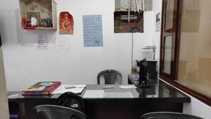 Una recepció amb un ordinador, una cadira i un petit altar.