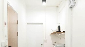 A compact kitchen with a refrigerator, sink, and countertop. - Unyak Room Ayutthaya (Ayutthaya)