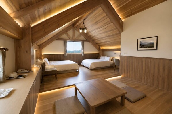 A cozy attic bedroom with two beds, a desk, and a view of the outdoors. - Star Villa (Nantou)