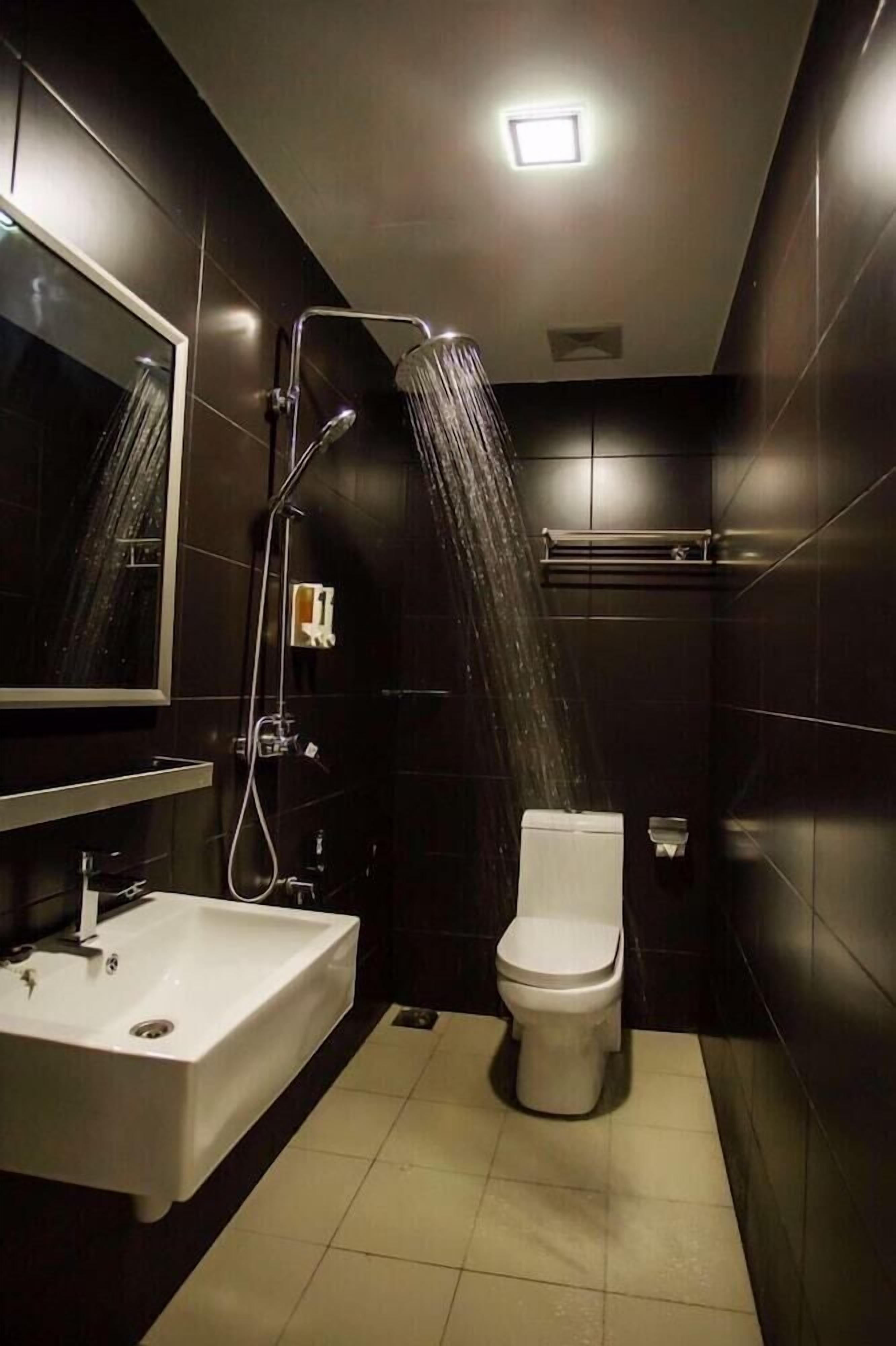 A modern bathroom with a shower, toilet, and sink.