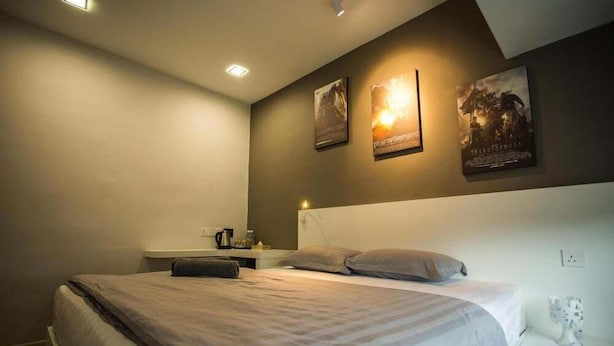 A bedroom with a bed, bedside tables, and wall-mounted posters. - Hollywood Hotel (Ipoh)