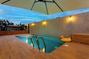 An indoor swimming pool with a wooden deck, a yellow rubber duck, and wall-mounted lights. - The Neenlawat Riverside (Phunphin)