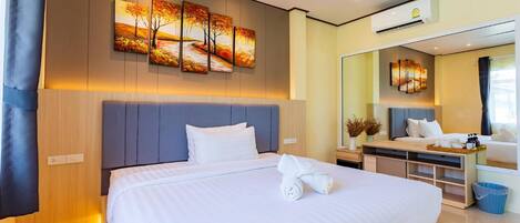 A modern hotel room with a large bed, a bedside table, a mirror, and a wall-mounted artwork.
