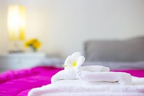 A bed with a white towel and a white flower on it. - The Neenlawat Riverside (Phunphin)