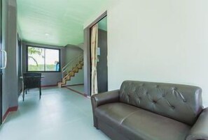 A living room with a sofa, a chair, a staircase, and a window. - Neenlawat Riverside (Phunphin)