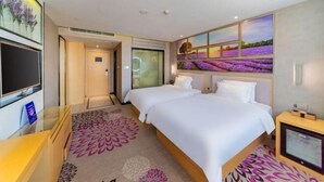 A hotel room with two beds, a TV, a desk, and a large window with a view of lavender fields. - Lavande Hotel (Foshan Shunde Jinlong Metro Station) (Foshan)