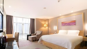 A hotel room with a bed, a desk, a chair, a lamp, and a painting on the wall. - Lavande Hotel (Foshan Shunde Jinlong Metro Station) (Foshan)