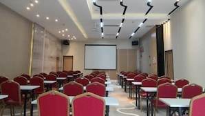 A conference room with rows of red chairs and white tables, a projector screen, and a whiteboard. - Lavande Hotel (Foshan Shunde Jinlong Metro Station) (Foshan)