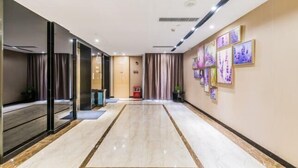 A spacious hallway with a marble floor, a reception area with a desk, and framed artwork on the walls. - Lavande Hotel (Foshan Shunde Jinlong Metro Station) (Foshan)