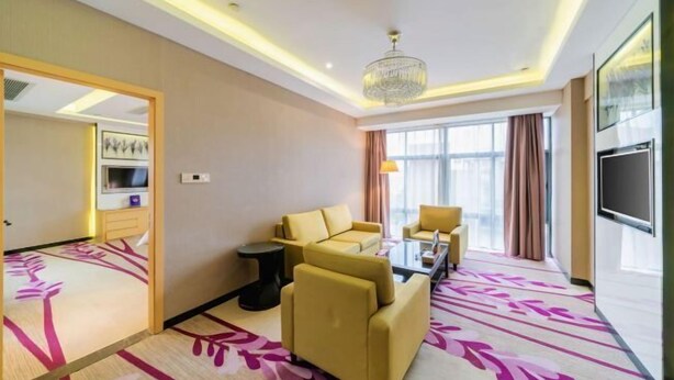A hotel room with a sofa set, a coffee table, a TV, and a chandelier. - Lavande Hotel (Foshan Shunde Jinlong Metro Station) (Foshan)