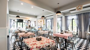 A restaurant with multiple tables and chairs, a check-in counter, and a bar area. - Reindeer Park Resort (Nakhon Nayok)