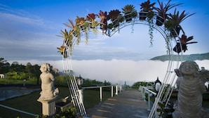 A pathway leading to a statue with an archway adorned with plants. - Hotel Viewpoint Khao Koh (Khao Kho)