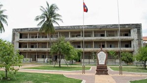 A multi-story building with a central courtyard, palm trees, and a flagpole. - 139 Guest House (Phnom Penh)