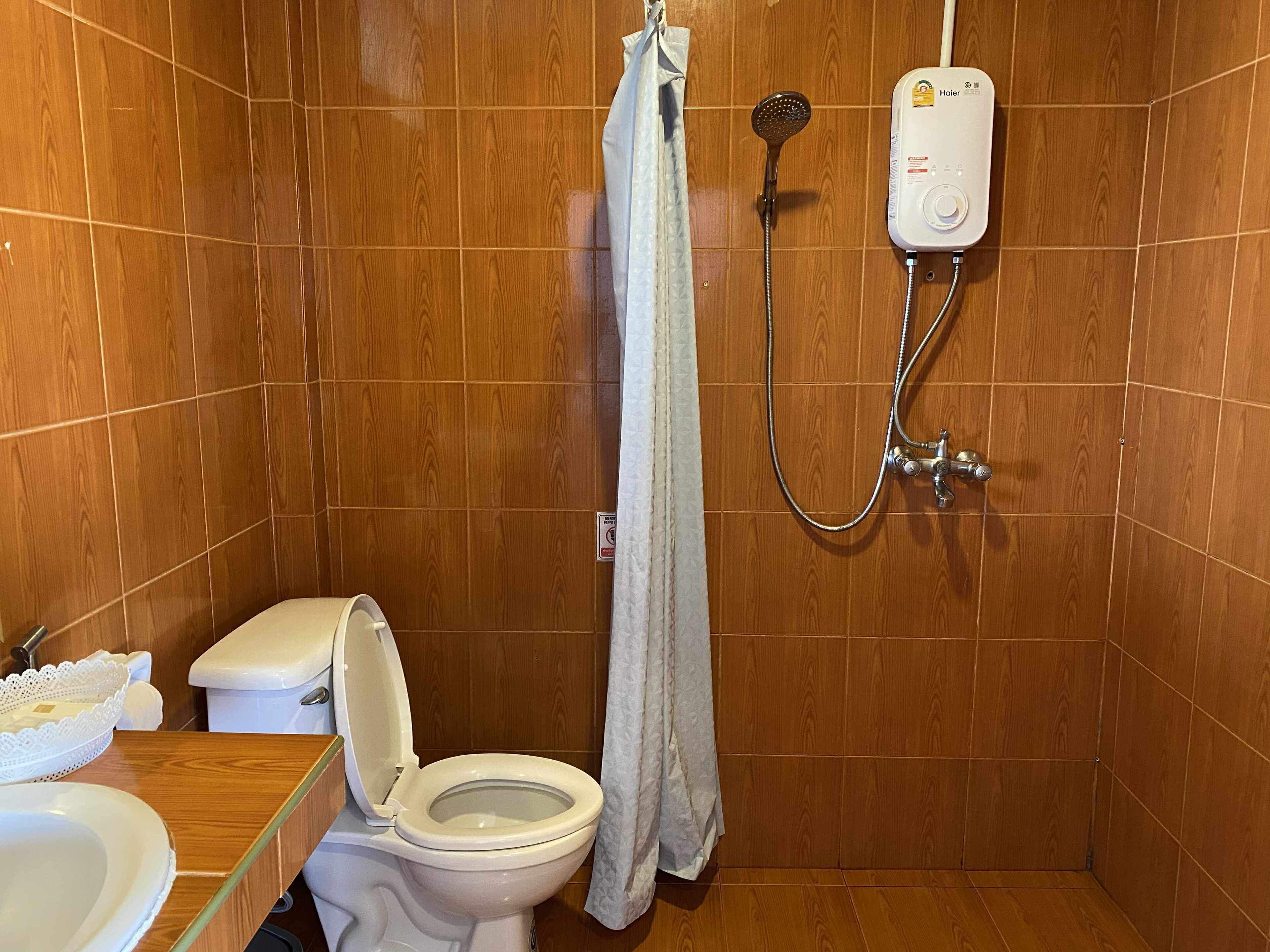 A bathroom with a shower, toilet, and sink.