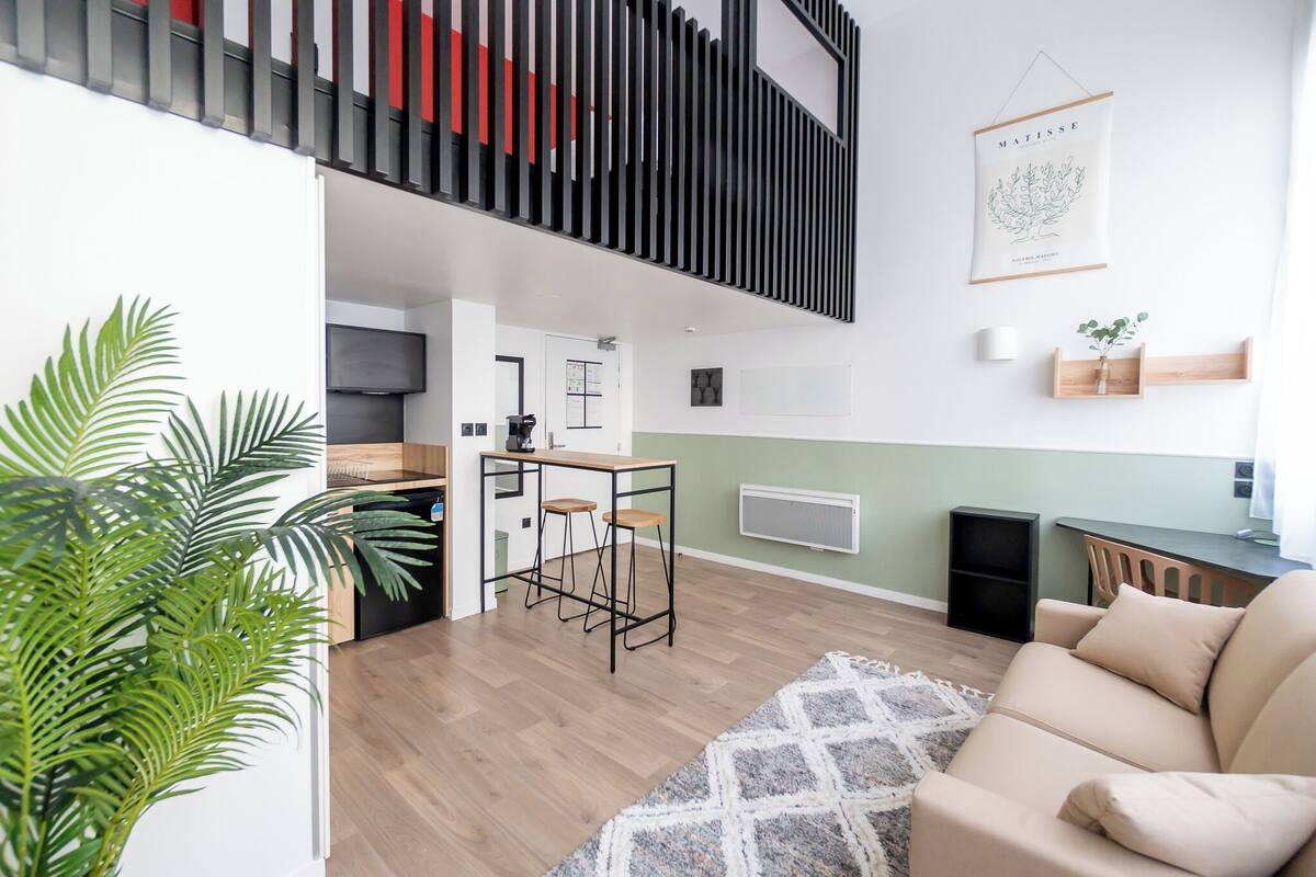 A modern apartment with a kitchen, dining area, and a living room with a sofa and a coffee table.