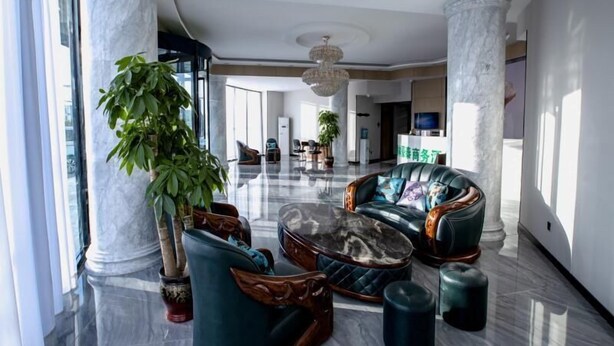 A spacious lobby with marble flooring, large columns, and a modern chandelier. There are leather sofas and a large potted plant. - Greentree Inn Tangshan Caofeidian District Nanbao Development Zone (Tangshan)