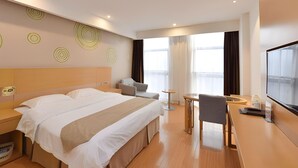 Une chambre d’hôtel moderne avec un grand lit, un bureau, une chaise et une petite table.