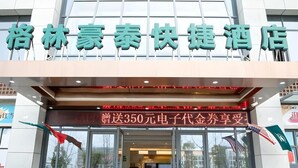 The entrance of a hotel with a sign in Chinese characters.