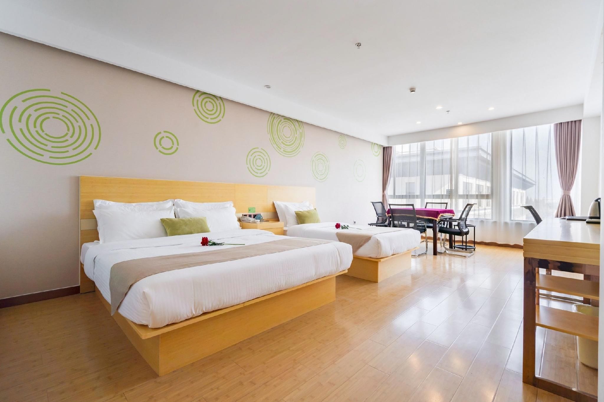 A hotel room with a large bed, a desk, and a view of the city.
