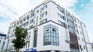 Ein mehrgeschossiges Gebäude mit moderner Architektur, das große Fenster und ein Flachdach aufweist.