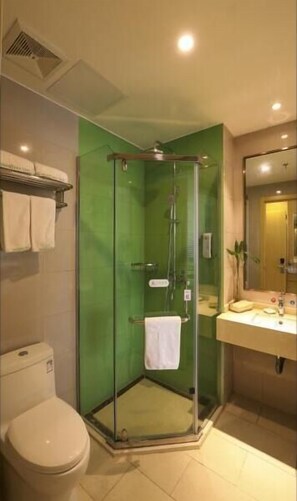 A bathroom with a glass-enclosed shower, a toilet, and a sink with a mirror. - Greentree Inn Wuxi Rongchuang Cultural Tourism City Nanquan Town Business Hotel (Wuxi)