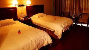 A hotel room with two single beds, a nightstand with a lamp, a chair, and a painting on the wall. - Greentree Inn Rizhao Yantai Road (Rizhao)
