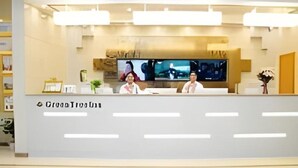 A reception desk with a modern design, featuring a flat surface and a logo. - Greentree Inn Anyang Tangyin Changhong Road (Anyang)
