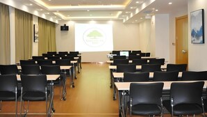 A conference room with rows of black chairs and tables, a projector screen, and a logo on the wall. - Greentree Inn Anyang Tangyin Changhong Road (Anyang)