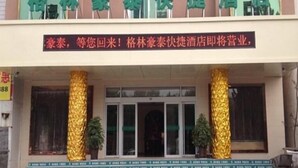 A hotel entrance with a signboard and two golden pillars. - Greentree Inn Shandong Dezhou Qihe County Party Committee Qilu Street Express Hotel (Dezhou)