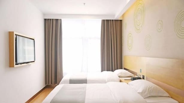 A hotel room with two beds, a TV mounted on the wall, and a large window with curtains. - Greentree Inn Gongqingcheng City Golf Avenue Peopl (Jiujiang)