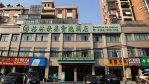 A hotel with multiple floors and balconies, featuring a prominent green sign with white text. - Greentree Inn Gongqingcheng City Golf Avenue Peopl (Jiujiang)