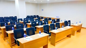 A conference room with rows of tables and chairs, equipped with water bottles and nameplates. - Greentree Inn Jiaxing Haiyan County Passenger Depo (Jiaxing)
