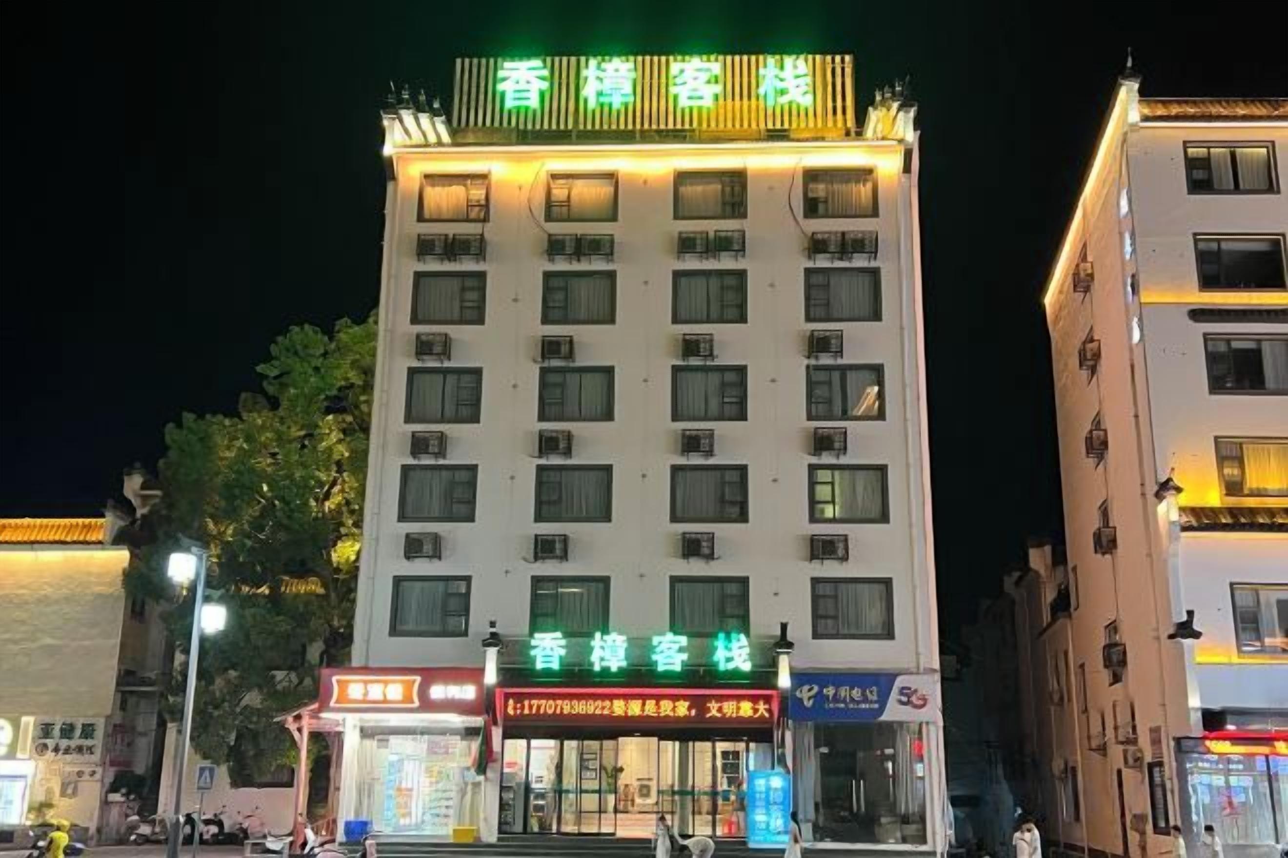 Een hotel met meerdere verdiepingen en een opvallend bord bovenop.
