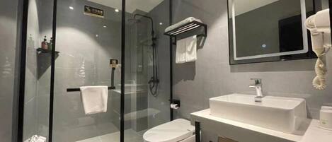 A modern bathroom with a glass shower enclosure, a white sink, and a mirror above the sink.