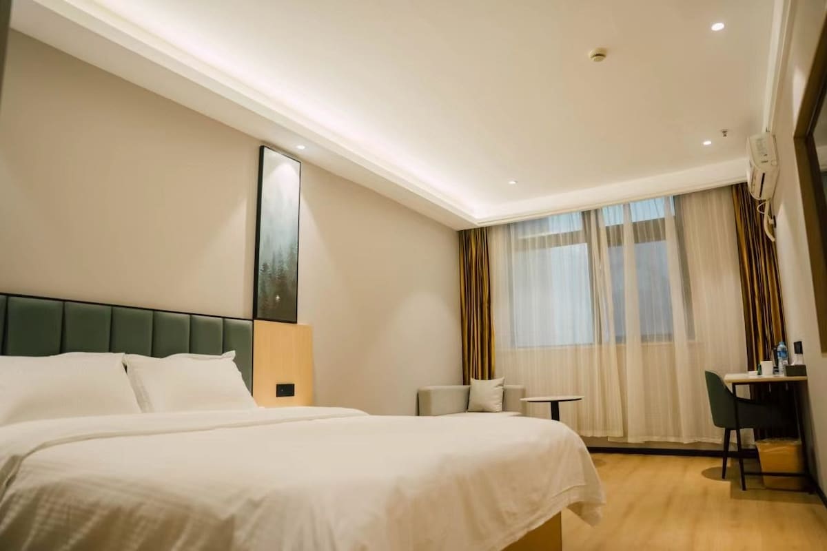 Una habitación de hotel con una cama grande, un escritorio y una silla.