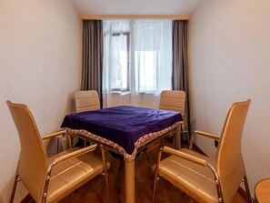 A room with a table and four chairs, a window with curtains, and a view of the outside. - Greentree Inn Hefei Changjiang West Road Zhenxing Road Subway Station Jiaqiao Yueshan International (Hefei)
