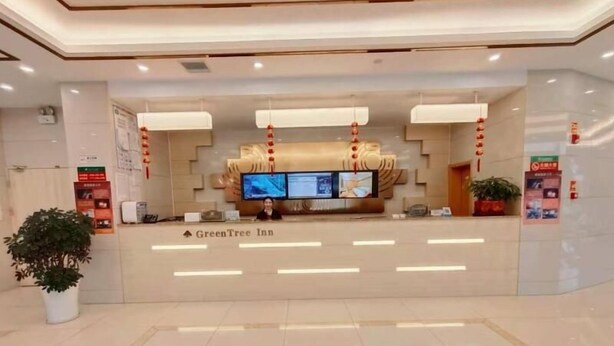 A reception area with a modern design, featuring a flat-screen TV, a digital display, and a reception desk. - Greentree Inn Yichun Development Zone Bus Terminal (Yichun)