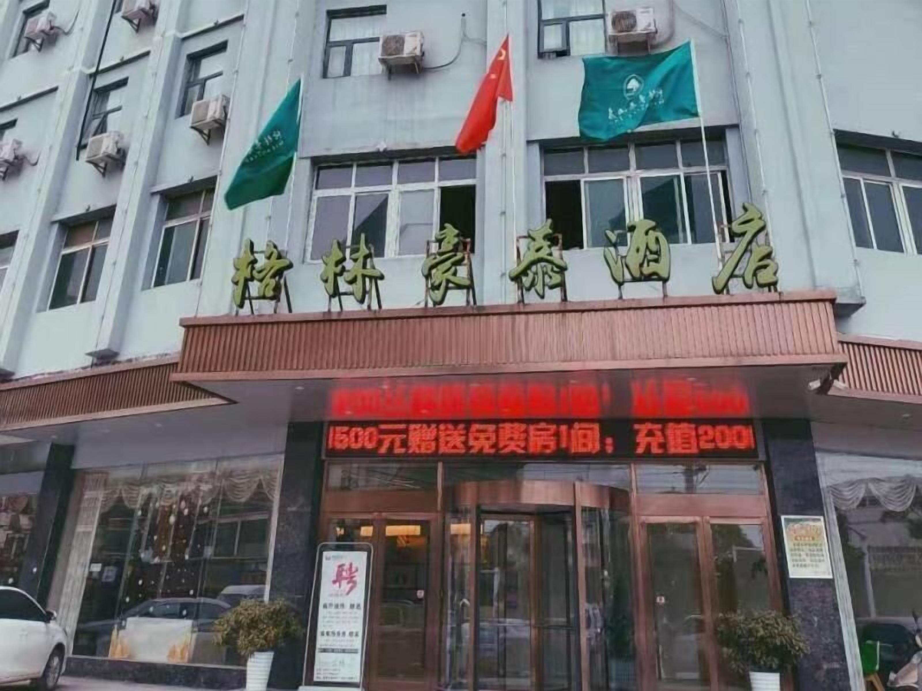Entrada de hotel com um painel digital exibindo um preço de 1500 yuan por quarto.