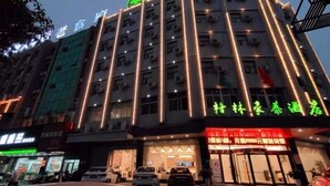 A multi-story hotel with illuminated vertical lines on the facade. - Greentree Inn Yichun Development Zone Bus Terminal (Yichun)