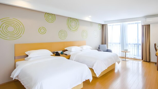 A hotel room with two beds, a small table, and a chair. - Greentree Inn Jiaxing Qixing Town Goverment (Jiaxing)