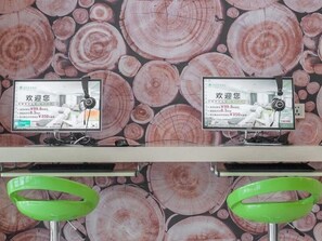 Relax in a stylish room with a unique wallpaper design, featuring two flat-screen TVs and a convenient workspace.