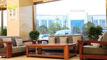 A lobby with wooden furniture, a large window, and a sign with symbols.