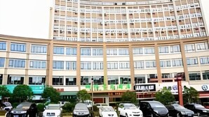 A multi-story hotel with a curved facade, numerous balconies, and a parking lot with various cars. - Greentree Inn Shangrao Yueliangwan Automobile City (Shangrao)
