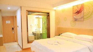 A hotel room with a bed, a bathroom with a shower, and a door leading to another room. - Greentree Inn Shangrao Yueliangwan Automobile City (Shangrao)
