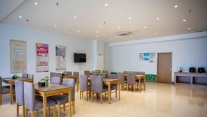 A spacious dining area with multiple tables and chairs, a flat-screen TV mounted on the wall, and various informational posters on the walls. - Greentree Inn Jiangyin Zhouzhuang Shiji Avenue Business Hotel (Wuxi)