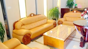 A modern living room with a sofa, coffee table, and a small round table. - Greentree Inn Jiangyin Zhouzhuang Shiji Avenue Business Hotel (Wuxi)