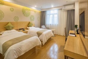 Une chambre d’hôtel avec deux lits, un bureau en bois, une petite table et un téléviseur.