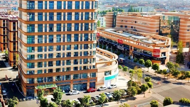 A modern hotel with a curved facade, multiple floors, and a rooftop sign. - Greentree Inn Cixi Zhouxiang Town Jiayue Plaza (Ningbo)